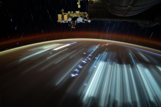 Indonesian city lights and lightning storms streak below