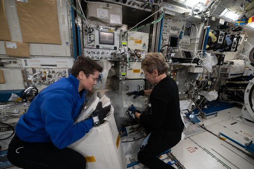 Astronauts Anne McClain and Peggy Whitson pack frozen research samples