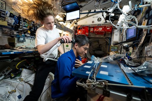 Nichole Ayers trims Takuya Onishi's hair aboard the International Space Station