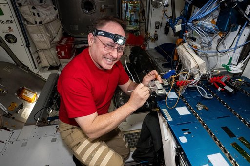NASA astronaut Mike Fincke replaces thermal tape on a spacesuit camera