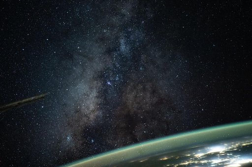 The Milky Way appears above Earth's bright atmospheric glow