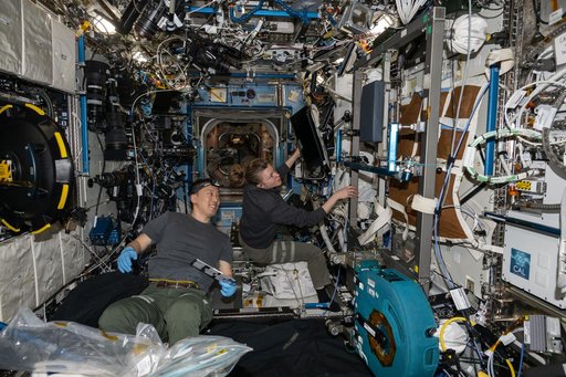 Expedition 73 Flight Engineers work together inside the Destiny laboratory module
