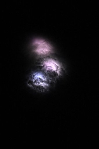 Lightning strikes illuminate the stormy cloud tops