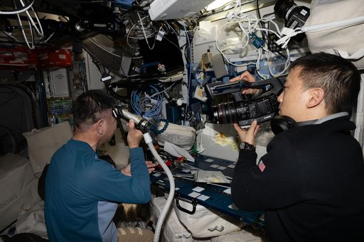Astronaut Kimiya Yui trims his own hair aboard the International Space Station