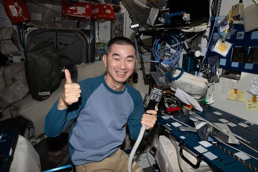 Astronaut Kimiya Yui smiles for a portrait after trimming his own hair