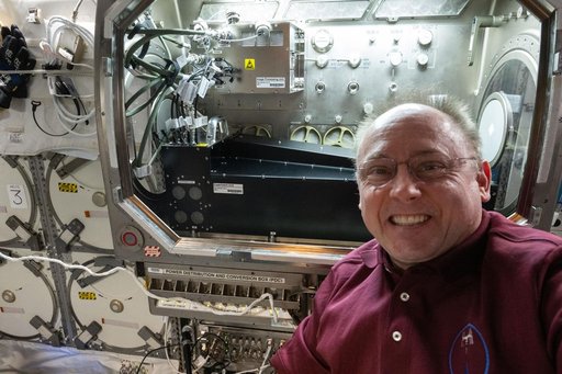 NASA astronaut Mike Fincke poses for a portrait in front of the Microgravity Science Glovebox