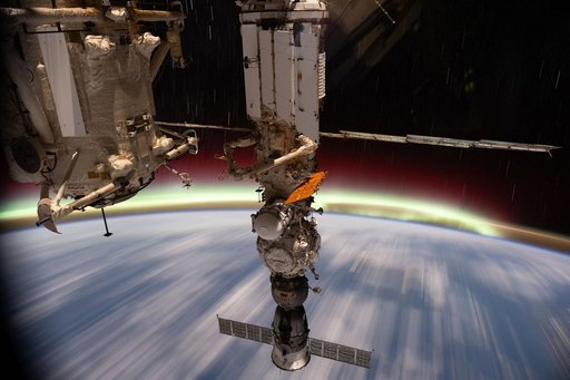 The aurora australis streams above Earth's horizon