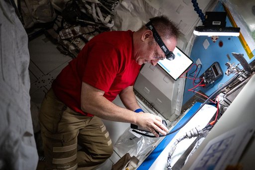 NASA astronaut performs electrical resistance measurements on the thermal control system