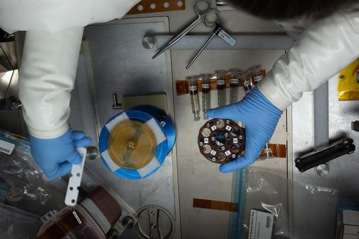 The gloved hands of NASA astronaut inside the Microgravity Science Glovebox
