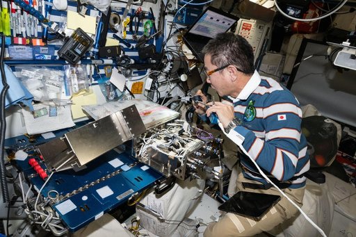 JAXA astronaut Kimiya Yui works on computer networking hardware