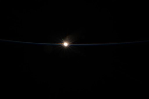 The last rays of an orbital sunset fade above Earth’s horizon