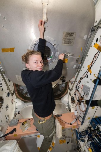 NASA astronaut Zena Cardman opens the hatch to the Cygnus XL cargo craft