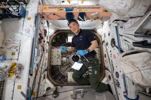 NASA astronaut Jonny Kim prepares to open the hatch to the Cygnus XL spacecraft