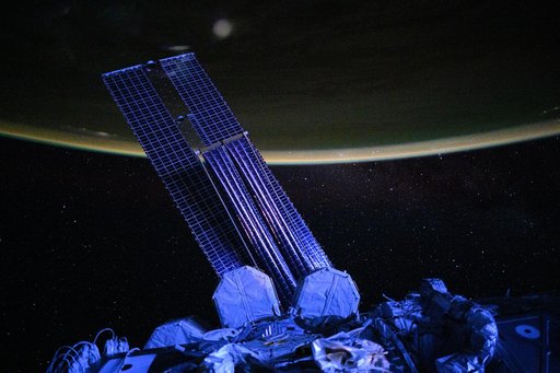 Moonlit, violet-hued view of the International Space Station’s main solar arrays