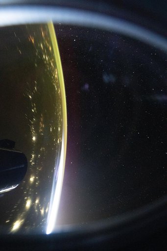 The city lights of Central Asia sparkle underneath a bright yellow airglow