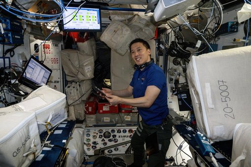 NASA astronaut Jonny Kim smiles for a portrait whle organizing cargo