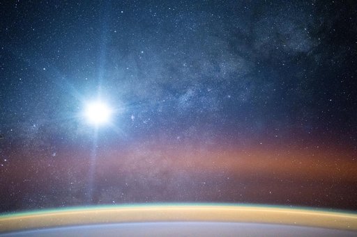 A bright airglow blankets Earth's horizon as the Milky Way illuminates the night sky