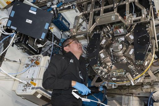 JAXA astronaut Kimiya Yui inspects and cleans hardware