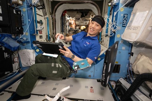NASA astronaut Jonny Kim performs laptop computer maintenance