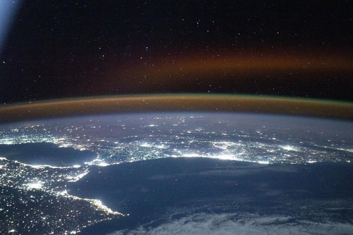 A red-yellow airglow blankets Earth's horizon above southwestern Europe and North Africa