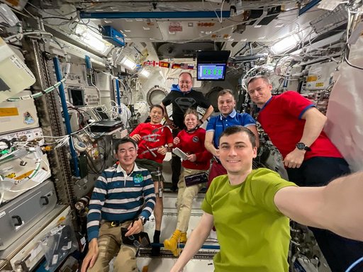 Expedition 73 crew members pose for a group selfie aboard the International Space Station