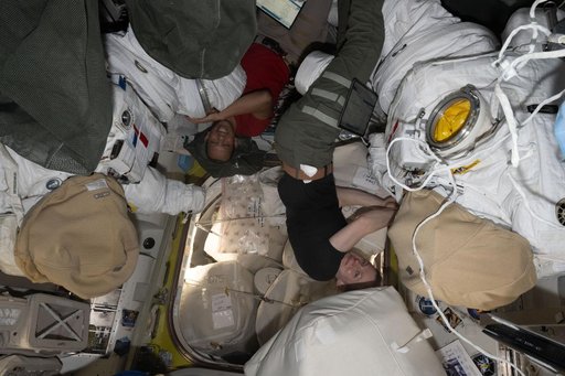 NASA astronauts Chris Williams and Zena Cardman work on spacesuit maintenance