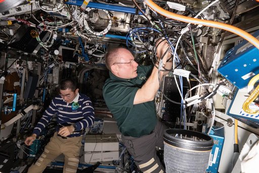 Astronauts Kimiya Yui and Mike Fincke work on maintenance activities