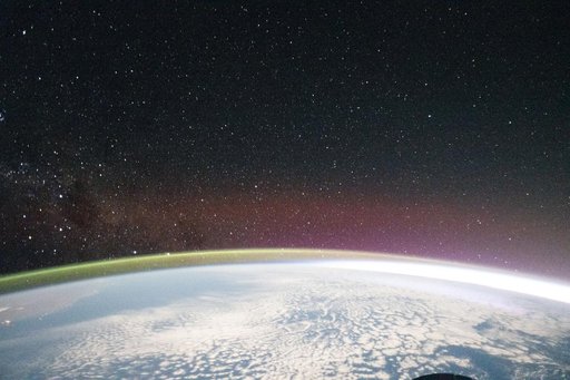 A yellow-green airglow crowns the horizon beneath a starry sky and a faint Milky Way