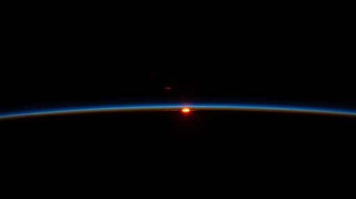The first rays of an orbital sunrise illuminate Earth’s atmosphere