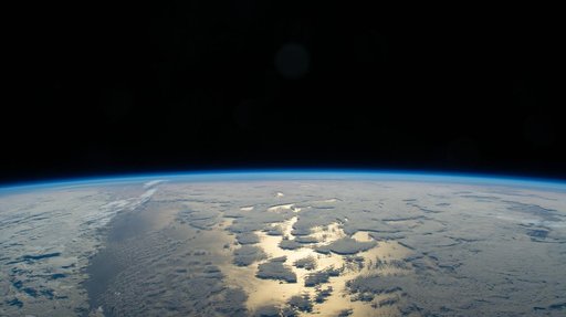 Earth's thin blue atmosphere traces the planet's horizon above the Pacific Ocean