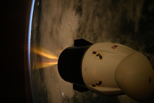 A SpaceX Dragon spacecraft fires its Draco engines
