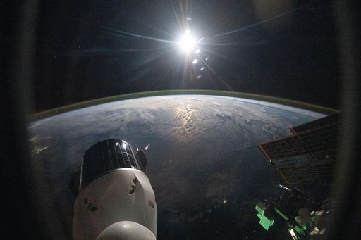 The sun begins setting above Earth's atmospheric glow