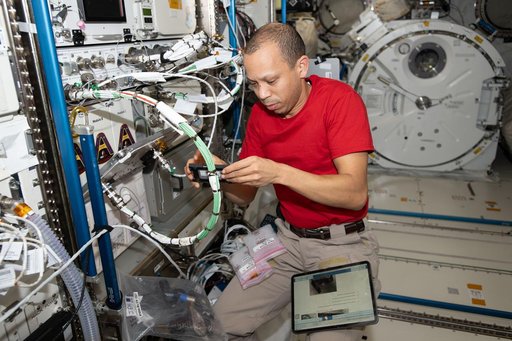 NASA astronaut Chris Williams swaps computer components inside scientific hardware