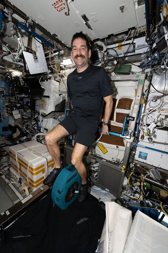 NASA astronaut Jack Hathaway smiles for a portrait while pedaling on the exercise cycle