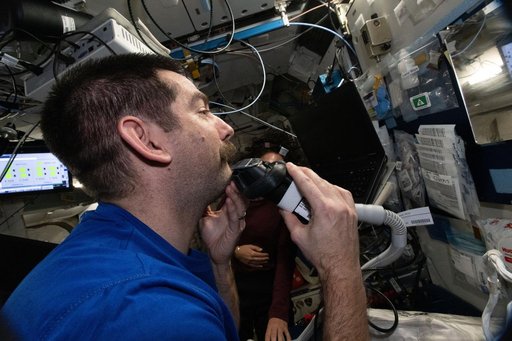 NASA astronaut Jack Hathaway gives himself a shave and trims his mustache