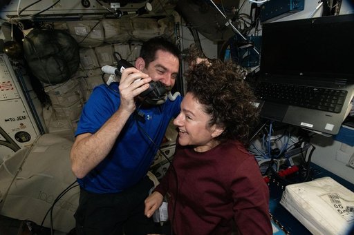 NASA astronaut Jack Hathaway trims the hair of fellow NASA astronaut Jessica Meir