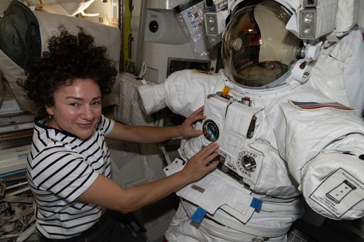 NASA astronaut Jessica Meir works on a spacesuit inside the Quest airlock