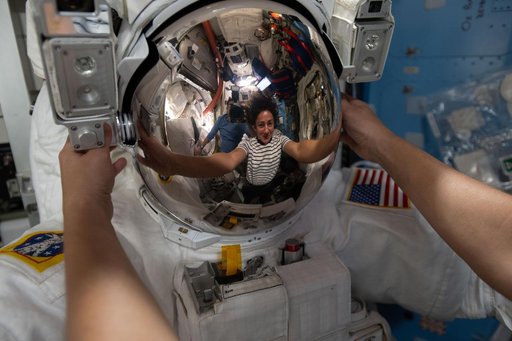 NASA astronaut Jessica Meir’s reflection is captured in a spacesuit helmet visor