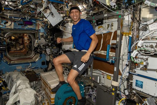 NASA astronaut Chris Williams pedals on the exercise cycle inside the Destiny laboratory module