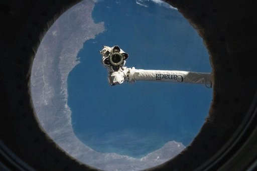 The Canadarm2 robotic arm is pictured from a window on the International Space Station