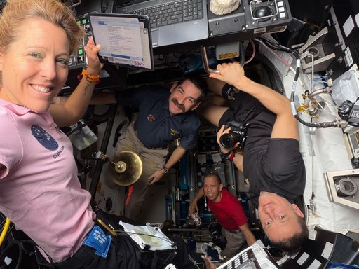 Expedition 74 crew members for a portrait together inside the International Space Station