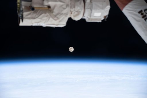 A waxing gibbous Moon is pictured above Earth's atmosphere