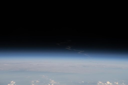 The exhaust plume left behind by Artemis II is pictured from the International Space Station