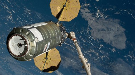 The Cygnus XL cargo spacecraft is held in the grips of the Canadarm2 robotic arm