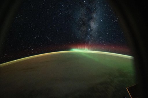A wispy aurora australis arcs across the Indian Ocean benaeth the Milky Way
