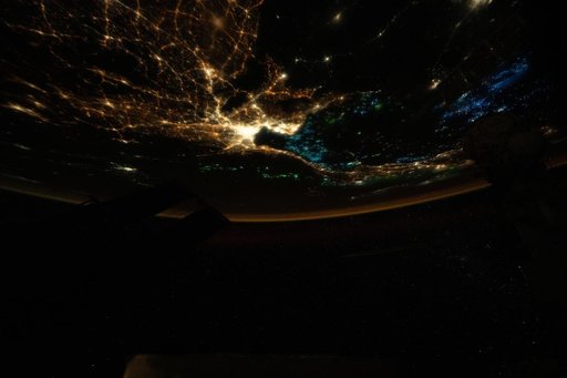 The blue lights of fishing boats dot the Gulf of Thailand contrasting with the city lights of Bangkok