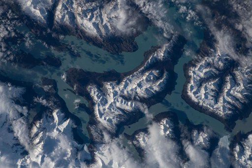 Turquoise-blue waters of Lake Argentino surrounded by the snow-capped Andes Mountains