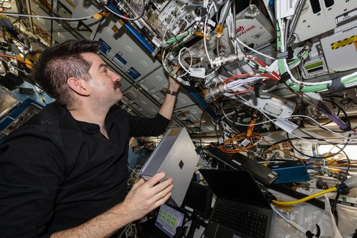 NASA astronaut Jack Hathaway prepares to install a research cassette into the Advanced Space Experiment Sample Processor-4
