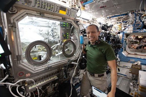 NASA astronaut Chris Williams shows off the Destiny laboratory module’s Microgravity Science Glovebox