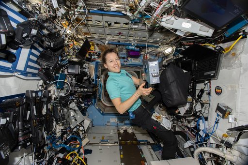 ESA astronaut Sophie Adenot shows off an Advanced Space Experiment Sample Processor-4 research cassette